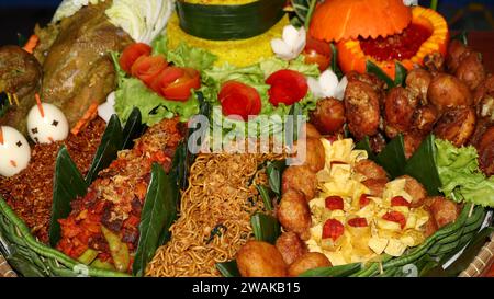 Riso a forma di cono o chiamato Nasi Tumpeng Un piatto di riso indonesiano festoso con contorni Foto Stock