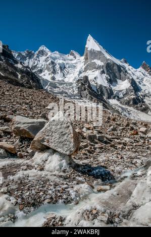 Pakistan, aree settentrionali dei monti Karakoram. Immagine pittorica delle pendici scolpite della vetta Lela, anche Leila, Layla, dal ghiacciaio Gondogoro. Una spedizione di arrampicate spagnola è accampata nella tacca evidente al centro della foto, Foto Stock