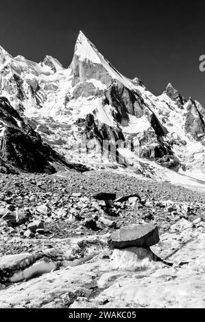 Pakistan, aree settentrionali dei monti Karakoram. Immagine pittorica delle pendici scolpite della vetta Lela, anche Leila, Layla, dal ghiacciaio Gondogoro. Una spedizione di arrampicate spagnola è accampata nella tacca evidente al centro della foto, Foto Stock