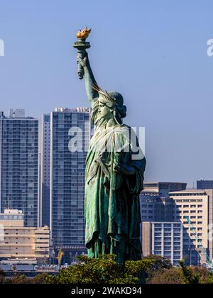 vista laterale della statua della libertà di tokyo a tutta altezza di fronte ai grattacieli del lungomare della baia di tokyo Foto Stock