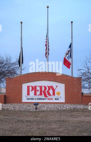 Perry, IA, USA. 5 gennaio 2024. Le bandiere di un cartello di benvenuto sono a metà dello staff a Perry, IA, venerdì 5 gennaio 2024. Una sparatoria scolastica nella scuola superiore e nella scuola media combinata ieri ha causato la morte di una vittima di sesta elementare dell'aggressione. e' morto per un apparente colpo di pistola autoinflitto. Altri cinque tra cui il preside della scuola sono rimasti feriti.Perry, popolazione 7900, si trova nella contea di Dallas, a circa 40 miglia a nord-ovest di Des Moines. (Immagine di credito: © Fritz Nordengren/ZUMA Press Wire) SOLO USO EDITORIALE! Non per USO commerciale! Foto Stock