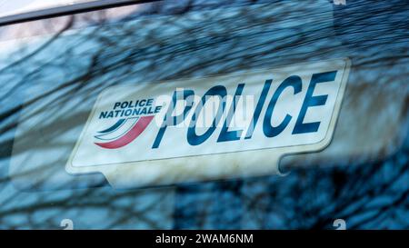 Primo piano della piastra dell'aletta parasole di un veicolo della polizia non contrassegnato con la parola "POLIZIA" e il logo della polizia nazionale francese Foto Stock