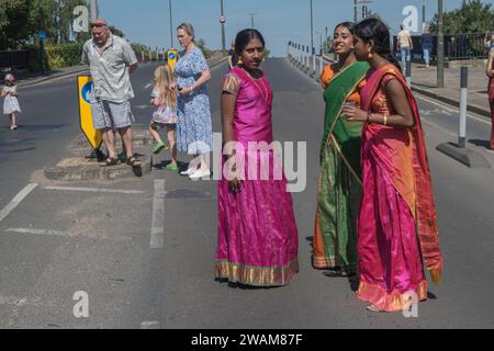 Immigrazione in Gran Bretagna, società multiculturale britannica, gruppo di giovani donne indù Tamil partecipano a un tradizionale festival annuale indù nella periferia di Wimbledon. Anche i residenti inglesi locali guardano la processione. Londra Inghilterra 2022 2000 HOMER SYKES Foto Stock