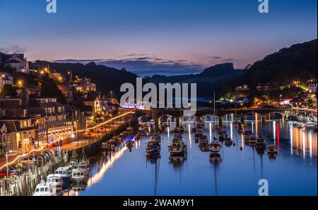 Looe, Cornovaglia, Regno Unito - 14 agosto 2023: Porto e città all'ora blu con luci riflesse nell'acqua Foto Stock