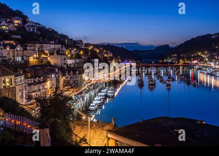 Looe, Cornovaglia, Regno Unito - 14 agosto 2023: Porto e città all'ora blu con luci riflesse nell'acqua Foto Stock