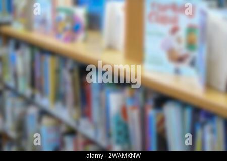 Libreria sfocata astratta con libri illustrati per bambini. Foto Stock