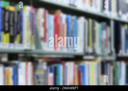 Immagine di sfondo di un'immagine sfocata dei libri sugli scaffali della biblioteca. Foto Stock