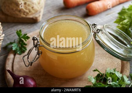 Brodo osseo fatto in casa in vaso di vetro, con verdure fresche Foto Stock