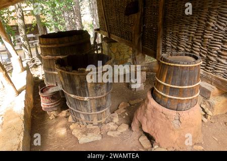 Fornace e tini per la fermentazione e la distillazione della stillage (borlanda) sotto il portico del presepe di mais nel Museo all'aperto Old Village di Sirogojno, Foto Stock