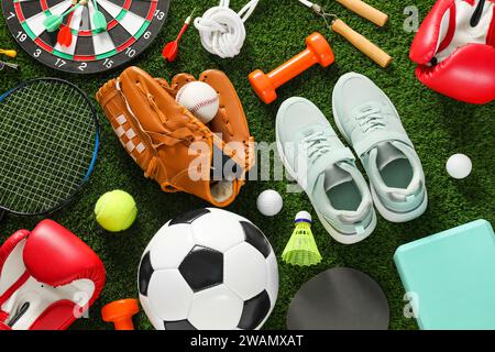Diverse attrezzature sportive e scarpe da ginnastica su prato verde, disteso piatto Foto Stock