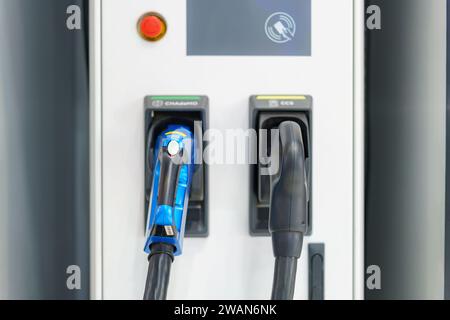 I caricatori EV veloci in posizione di parcheggio le stazioni di ricarica sono pronte per alimentare rapidamente i veicoli elettrici, a simboleggiare la perfetta integrazione di cutting-e. Foto Stock