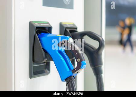 I caricatori EV veloci in posizione di parcheggio le stazioni di ricarica sono pronte per alimentare rapidamente i veicoli elettrici, a simboleggiare la perfetta integrazione di cutting-e. Foto Stock
