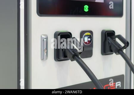 I caricatori EV veloci in posizione di parcheggio le stazioni di ricarica sono pronte per alimentare rapidamente i veicoli elettrici, a simboleggiare la perfetta integrazione di cutting-e. Foto Stock