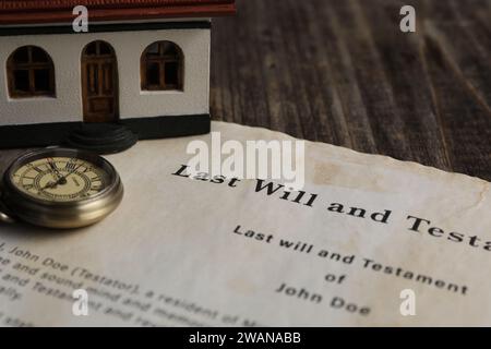 Last Will e Testament con orologio da tasca e modello di casa su tavolo di legno, primo piano Foto Stock