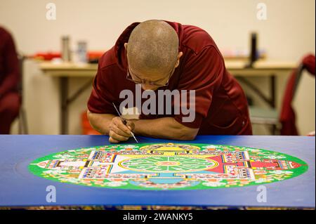 Un monaco buddista tibetano lavora per creare un mandala durante un evento di tour tenuto libero al pubblico dagli amici del Tibet di Placerville Foto Stock