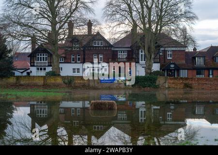 Cookham, Regno Unito. 6 gennaio 2024. Inondazioni fuori dal Chartered Institute of Marketing di Cookham, Berkshire. La strada principale che attraversa il villaggio di Cookham nel Berkshire è stata chiusa a causa delle inondazioni dal Tamigi. L'acqua piovana si è riversata nel Cookham Moor, un luogo popolare ogni estate per il concerto pop Let's Rock the Moor. Credito: Maureen McLean/Alamy Live News Foto Stock