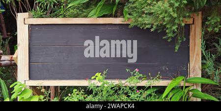 Tavoletta di legno vuota in un bellissimo giardino Foto Stock