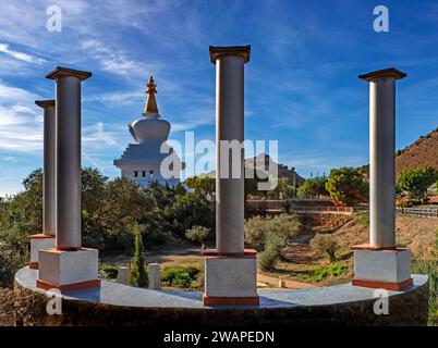 Incorniciato da colonne in un parco vicino, lo Stupa buddista a Benalmádena, nella provincia di Malaga, nella regione andalusa della Spagna meridionale. Foto Stock