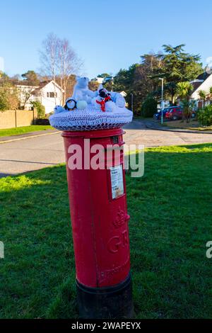 Poole, Dorset, Regno Unito. 6 gennaio 2024. Meteo Regno Unito: Viene emesso un allarme per basse temperature in tutto il paese quando le temperature sono impostate su plummet. Il Consiglio del Dorset ha innescato le sue disposizioni di emergenza per il freddo per i dormienti sconnessi a causa del significativo calo delle temperature. Un tema freddo con igloo e animali e persone che vivono in condizioni climatiche fredde, sono visti su un top a maglia di una cassetta postale rossa a Poole, Dorset - top di una cassetta postale, top di cassetta per lettere, top di cassetta per lettere, topper, bombe su filati, bomba a filato. Crediti: Carolyn Jenkins/Alamy Live News Foto Stock