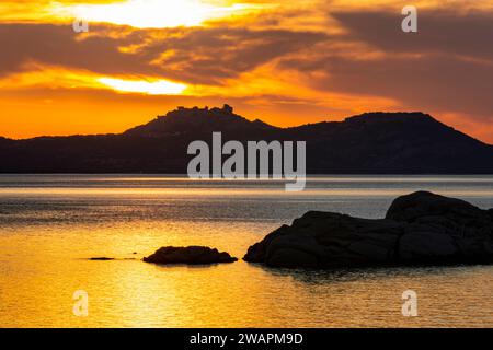 Colorata vista dorata del tramonto: Costa mediterranea del Nord Sardegna e lontane isole di Caprera e la Maddalena con vivace cielo Rosso e tramonto. Foto Stock