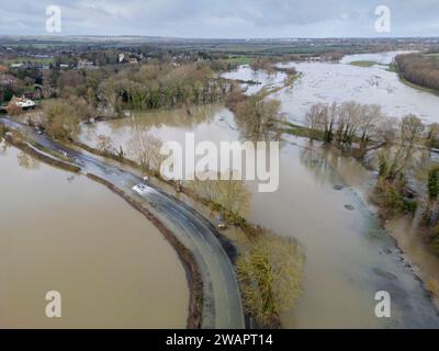 Grantchester, Cambridge, 6 gennaio 2024. Il fiume Cam ha fatto irruzione sulle sue sponde che inondano la strada attraverso il villaggio, i campi circostanti e i famosi prati di Grantchester dopo settimane di tempo umido. Le auto possono ancora passare con cura. Periodi prolungati di forti piogge hanno causato inondazioni in gran parte del Regno Unito quest'inverno. Crediti: Julian Eales/Alamy Live News Foto Stock