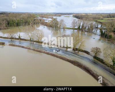 Grantchester, Cambridge, 6 gennaio 2024. Il fiume Cam ha fatto irruzione sulle sue sponde che inondano la strada attraverso il villaggio, i campi circostanti e i famosi prati di Grantchester dopo settimane di tempo umido. Le auto possono ancora passare con cura. Periodi prolungati di forti piogge hanno causato inondazioni in gran parte del Regno Unito quest'inverno. Crediti: Julian Eales/Alamy Live News Foto Stock