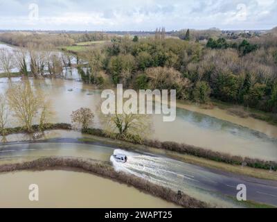 Grantchester, Cambridge, 6 gennaio 2024. Il fiume Cam ha fatto irruzione sulle sue sponde che inondano la strada attraverso il villaggio, i campi circostanti e i famosi prati di Grantchester dopo settimane di tempo umido. Le auto possono ancora passare con cura. Periodi prolungati di forti piogge hanno causato inondazioni in gran parte del Regno Unito quest'inverno. Crediti: Julian Eales/Alamy Live News Foto Stock