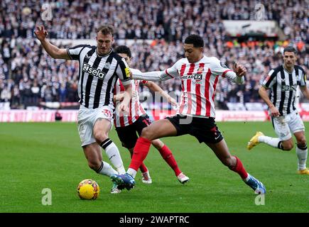 Dan Burn del Newcastle United (a sinistra) e Jobe Bellingham del Sunderland si scontrano per il pallone durante la partita del terzo turno della Emirates fa Cup allo Stadium of Light, Sunderland. Data immagine: Sabato 6 gennaio 2024. Foto Stock