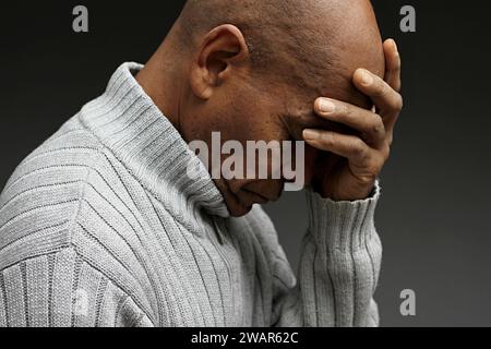 Pregare dio per il perdono l'uomo caraibico che prega con sfondo grigio nero con la gente stock immagine foto stock Foto Stock