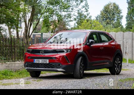 SENOV, REPUBBLICA CECA - 4 AGOSTO 2023: Nuovissima Opel Mokka rossa di seconda generazione parcheggiata su strada ghiaiosa Foto Stock