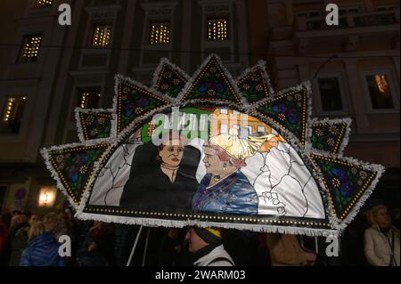 Dreikönigsingen und Glöcklerlauf am Rathausplatz in Gmunden, im oberösterreichischen Salzkammergut, AM 05.01.2024. Sowohl das Dreikönigssingen als auch der Glöcklerlauf sind alte, eingeprägte Brauchtumsveranstaltungen im Salzkammergut in Österreich. während des Glöcklerlaufs tragen junge Burschen prächtig geschmückte Laternenkappen mit meist lokalen Motiven am Kopf. Dabei wird durch laufen, springen und tanzen, mit an Gürteln der Weiß Gekleideten angebrachten Glocken, entsprechend Lärm gemacht und dazu gesungen Damit treiben die Glöckler in der letzten Rauhnacht der Saison, dem 5,1. eines jede Foto Stock