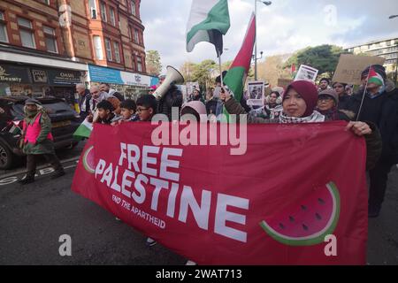 Oltre 200 persone hanno marciato attraverso Bournemouth per un cessate il fuoco a Gaza il 6 gennaio 2024. Con molti vestiti di bianco e con i nomi di bambini uccisi a Gaza, la marcia è stata una potente immagine visiva, chiedendo un cessate il fuoco a Gaza. La marcia bloccò la Pier Approach Road, dove venivano accesi i fumogeni. La marcia è stata organizzata da Palestine Solidarity Bournemouth. Foto Stock