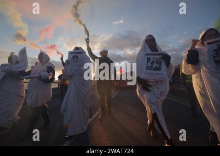 Oltre 200 persone hanno marciato attraverso Bournemouth per un cessate il fuoco a Gaza il 6 gennaio 2024. Con molti vestiti di bianco e con i nomi di bambini uccisi a Gaza, la marcia è stata una potente immagine visiva, chiedendo un cessate il fuoco a Gaza. La marcia bloccò la Pier Approach Road, dove venivano accesi i fumogeni. La marcia è stata organizzata da Palestine Solidarity Bournemouth. Foto Stock