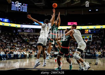 Winston-Salem, NC, USA. 6 gennaio 2024. La guardia degli Hurricanes di Miami (FL) Matthew Cleveland (0) spara sull'attaccante della Wake Forest Efton Reid III (4) nel match di pallacanestro ACC al LJVM Coliseum di Winston-Salem, NC. (Scott Kinser/CSM). Credito: csm/Alamy Live News Foto Stock