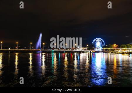 Ginevra, Svizzera 8 settembre 2023: Vista notturna sul fiume con bellissimi riflessi della città di Ginevra in Svizzera Foto Stock