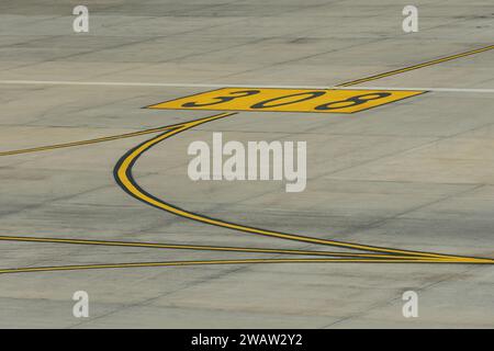 Linee gialle per il movimento degli aeromobili con numeri di parcheggio sul piazzale dell'aeroporto Foto Stock