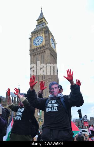 Londra, Regno Unito. 6 gennaio 2024. I manifestanti con le mani insanguinate indossano maschere facciali con le foto di David Cameron, Benjamin Netanyahu e Rishi Sunak. Circa un migliaio di sostenitori della Palestina, compresi i gruppi di attivisti Sisters Uncut e BLM, marciarono attraverso Westminster da St James's Park verso Parliament Square, dove i manifestanti erano contenuti da un cordone di polizia, e impose condizioni che limitavano ulteriori movimenti. Credito: Fotografia dell'undicesima ora/Alamy Live News Foto Stock