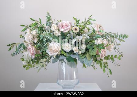 Bellissimo bouquet di fiori misti in un vaso di vetro su sfondo grigio Foto Stock