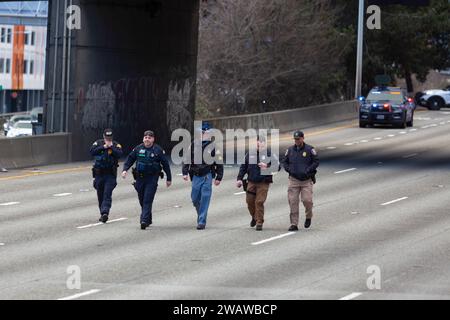 Seattle, Washington, USA. 6 gennaio 2024. I membri del dipartimento di polizia di Seattle si avvicinano ai manifestanti che hanno bloccato la i-5 in direzione nord in solidarietà con la Palestina. Le proteste settimanali che chiedono un cessate il fuoco immediato sono aumentate dallo scoppio della guerra tra Israele e gruppi militanti palestinesi guidati da Hamas nella Striscia di Gaza in ottobre. Credito: Paul Christian Gordon/Alamy Live News Foto Stock