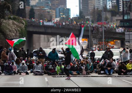 Seattle, Washington, USA. 6 gennaio 2024. I manifestanti bloccano la i-5 in direzione nord in solidarietà con la Palestina. Le proteste settimanali che chiedono un cessate il fuoco immediato sono aumentate dallo scoppio della guerra tra Israele e gruppi militanti palestinesi guidati da Hamas nella Striscia di Gaza in ottobre. Credito: Paul Christian Gordon/Alamy Live News Foto Stock