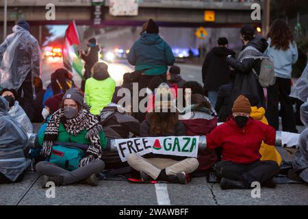 Seattle, Washington, USA. 6 gennaio 2024. I manifestanti bloccano la i-5 in direzione nord in solidarietà con la Palestina. Le proteste settimanali che chiedono un cessate il fuoco immediato sono aumentate dallo scoppio della guerra tra Israele e gruppi militanti palestinesi guidati da Hamas nella Striscia di Gaza in ottobre. Credito: Paul Christian Gordon/Alamy Live News Foto Stock