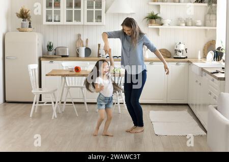 Madre e figlia che si divertono, ballano in cucina Foto Stock