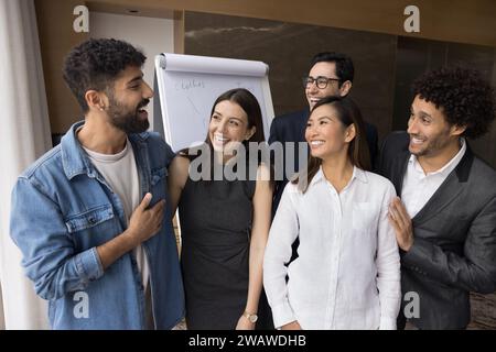 Colleghi d'ufficio positivi e diversificati che si divertono a lavorare in squadra e a collaborare Foto Stock
