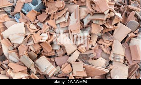 Mattonelle di mattoni di spazzatura sul cantiere piastrelle di terracotta rotte dal tetto bruciato piastrelle rosse di argilla frantumate Foto Stock