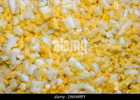 tagliare l'uovo di gallina a cubetti piccoli in grandi quantità. preparazione dell'insalata. Foto Stock