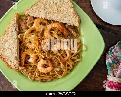 Spaghetti fatti in casa con gamberi e fette di pane integrale. Foto Stock