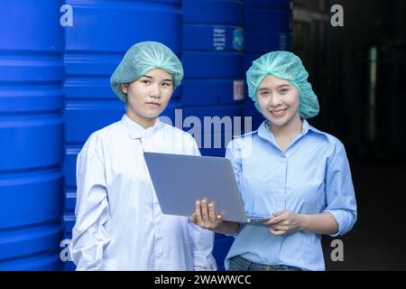 Il team di ingegneri responsabili del controllo della qualità dell'acqua ispeziona i serbatoi dell'acqua nello stabilimento dell'industria delle bevande per garantire gli standard di pulizia. Foto Stock