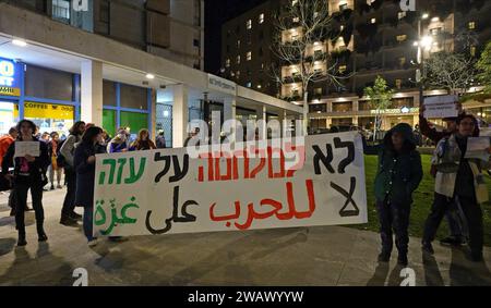 Gli attivisti israeliani di sinistra cantano slogan, battono batteria e tengono uno striscione che recita "No alla guerra a Gaza” durante una protesta contro la guerra che chiede un cessate il fuoco e una soluzione diplomatica alla guerra Israele-Hamas in corso il 6 gennaio 2024 a Gerusalemme. Israele Foto Stock