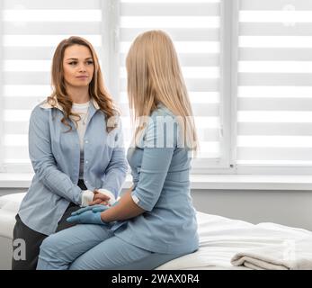 Momento di relax: Una donna trova riposo e risponde alle domande sulla cura della pelle in una piacevole atmosfera di una clinica di bellezza. Foto Stock