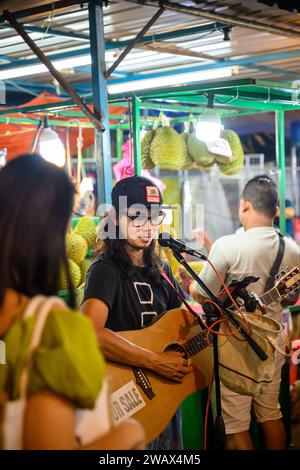 Un musicista di strada in Jalan Alor food Street, Kuala Lumpur, Malesia Foto Stock